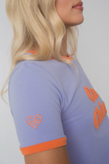 T -Shirt "La Chica" in Lavendel mit orangefarbenem Text und Trimm - Cosma